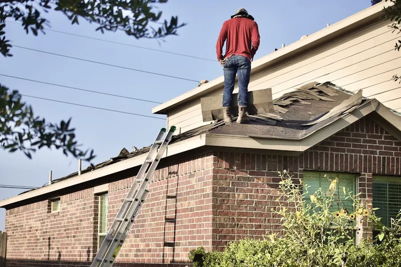 Professional roofer working on a residential roof in Canoe Place